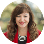 Julie Lenzer with red lipstick, brown hair and a red jacket